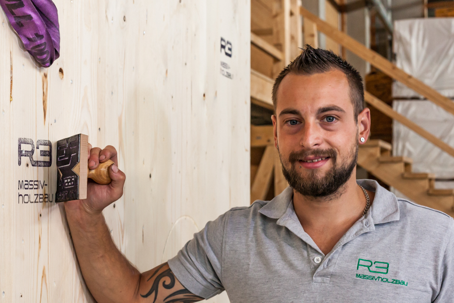 Mitarbeiter stempelt Massivholzwand